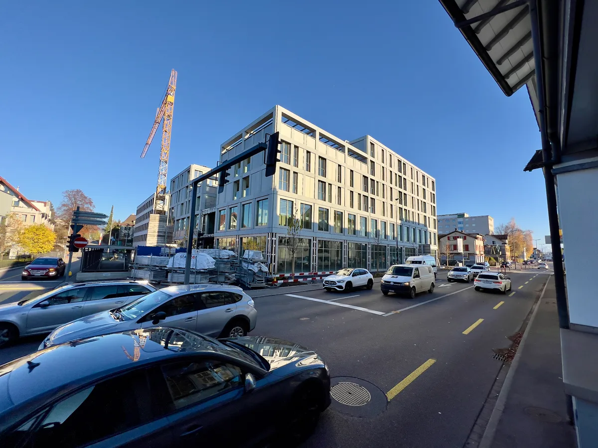 Man sieht mehrere Autos auf der Rapperswilerstrasse in Wetzikon mit Blickrichtung Hinwil. Im Hintergrund sieht man einen fast fertiggestellten Neubau, neben dem noch ein Kran aufgebaut ist.